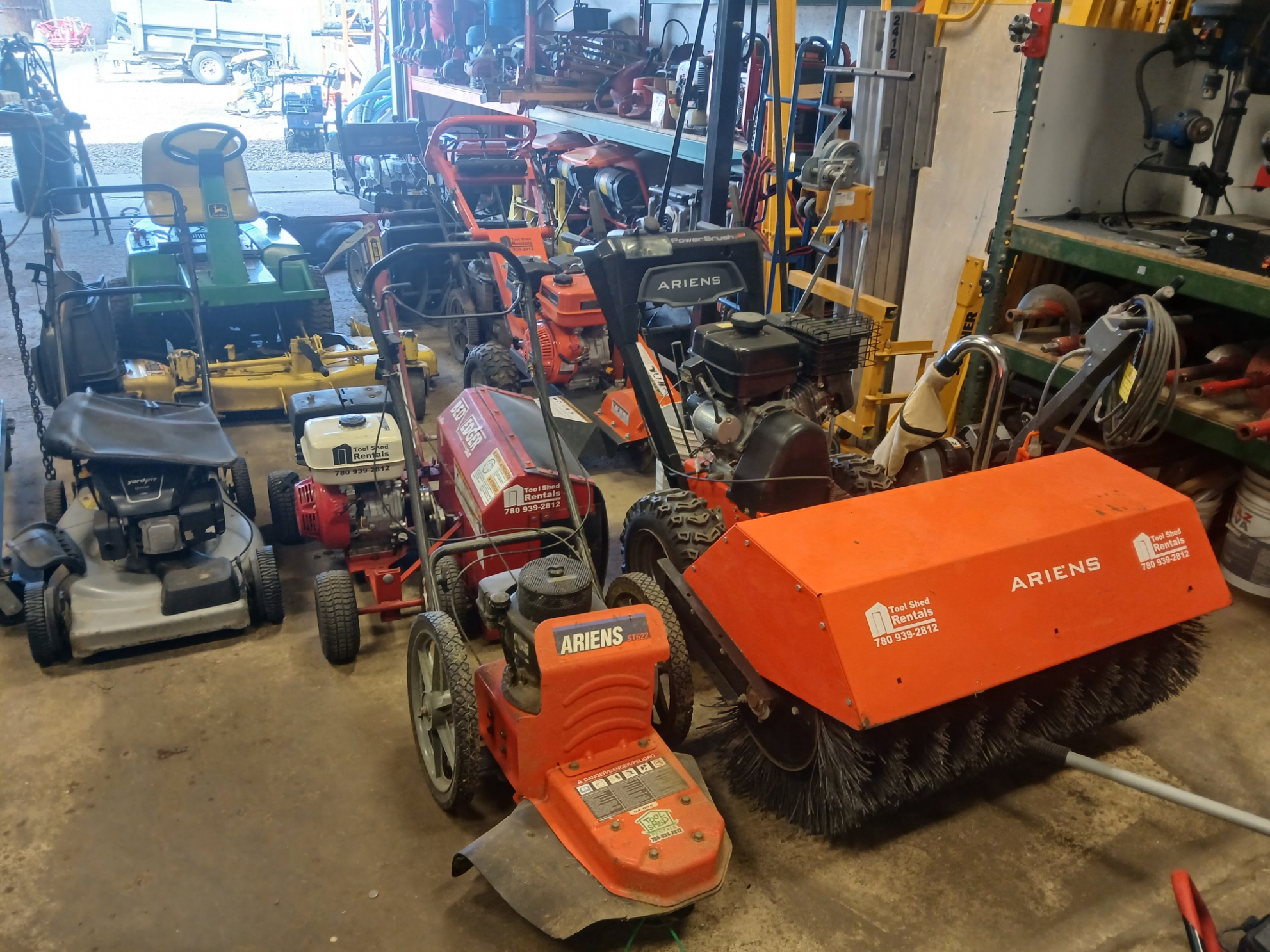 Shop floor with mowers, sweepers and small engine equipment lined up